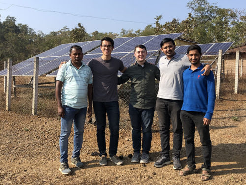 group of people in india in front of solar panels