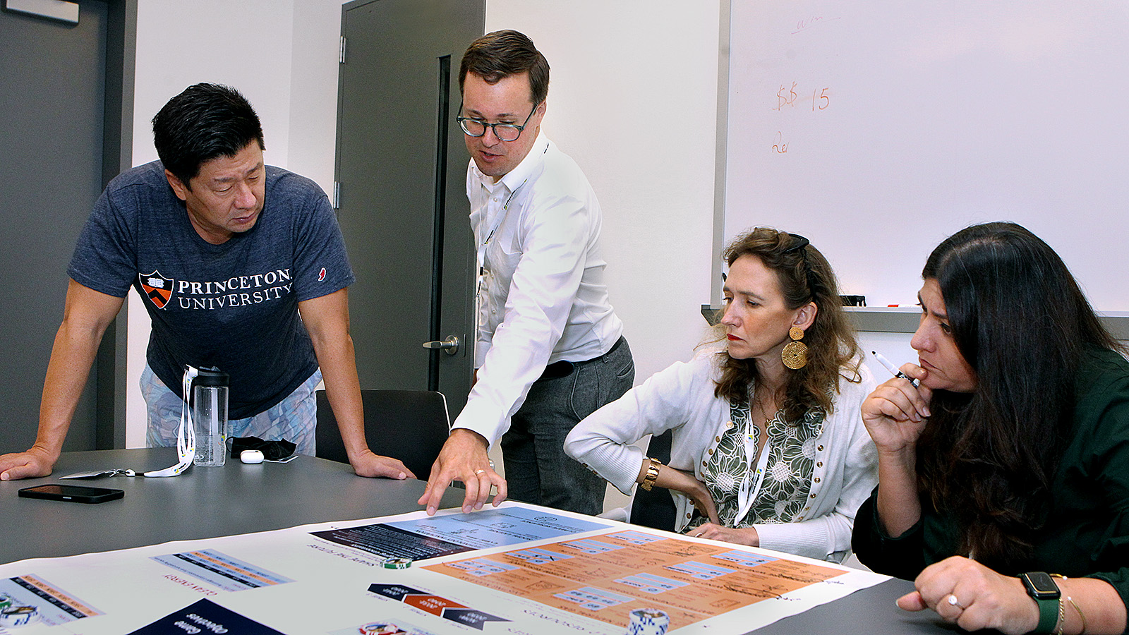 Left to right, YGL participants Dorjee Sun, Anne-Sophie Grouchka, and Asma Siddiki, listen intently as Jesse Jenkins, center, explains the rules of the energy planning game. (Photo by Frank Wojciechowski)