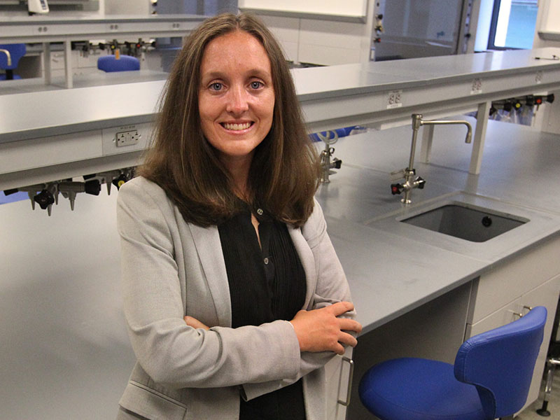 A woman stands in a lab.