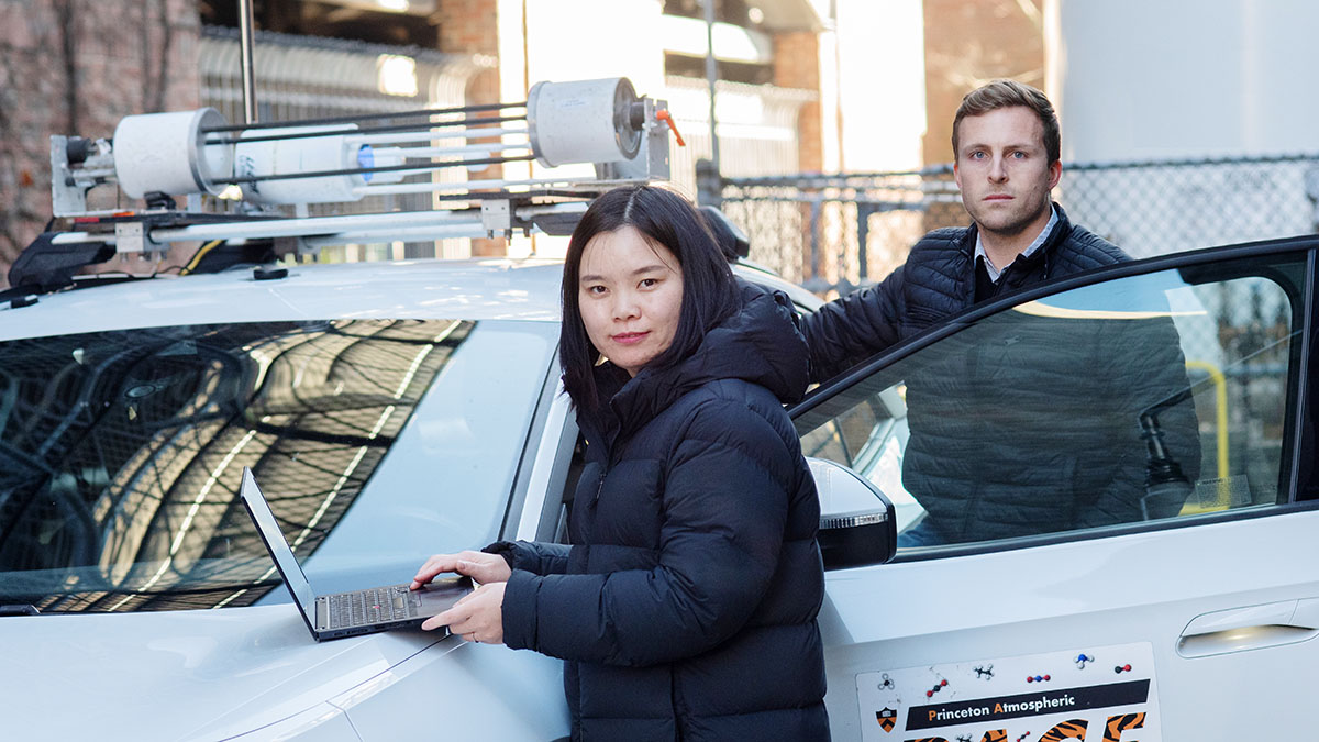 Two researchers are photographed next to a mobile methane emissions lab.