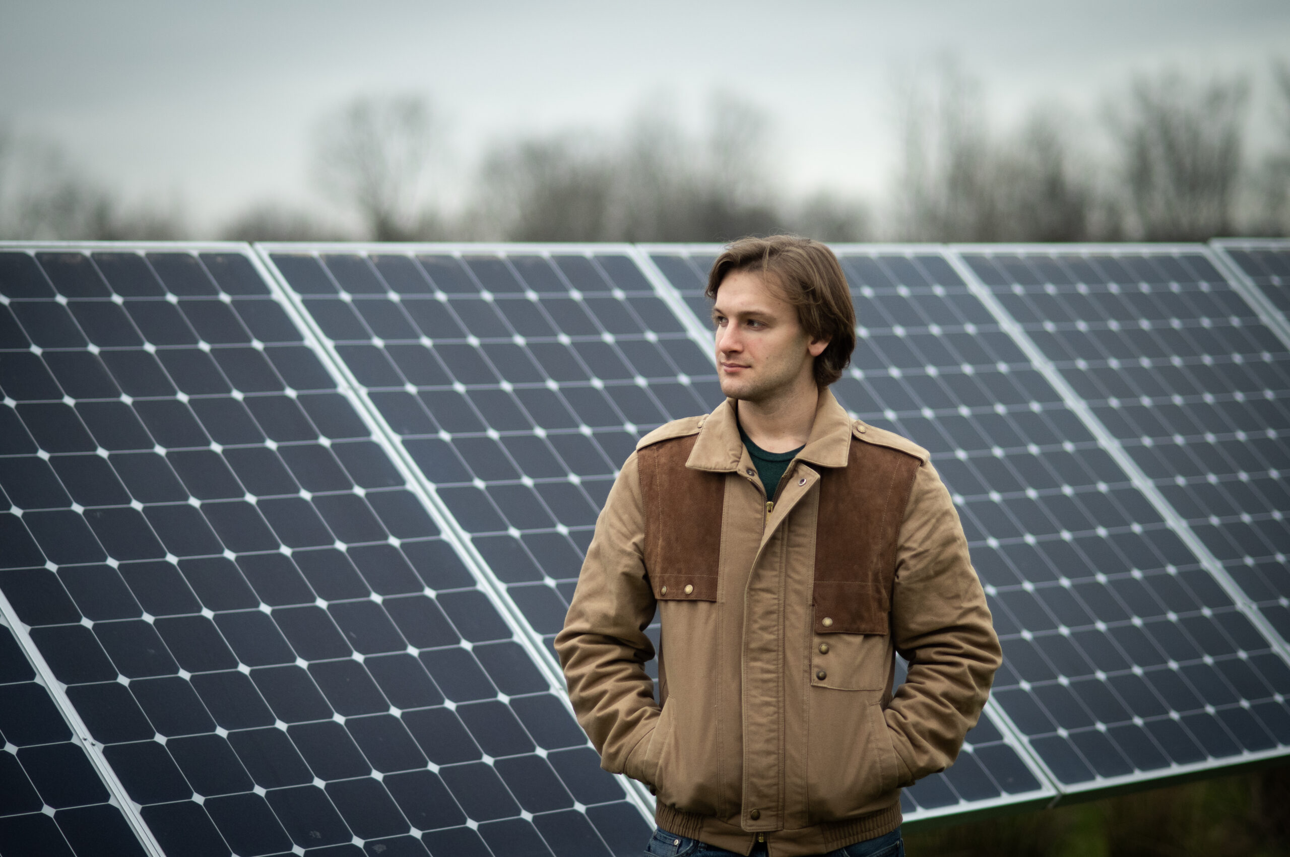A man stands in front of a solar panel array.