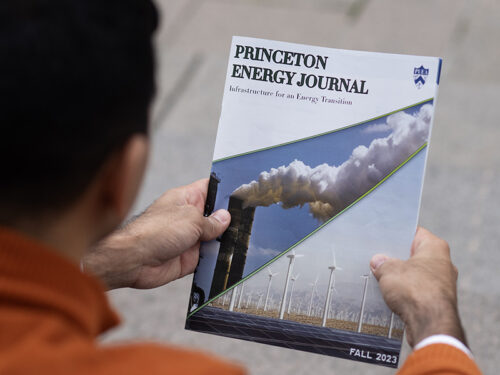 A young man holds a magazine titled the Princeton Energy Journal.