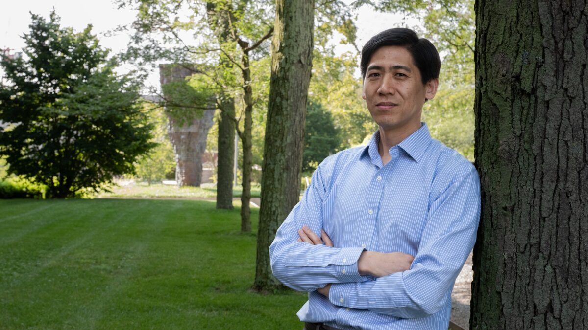 A man leaning against a tree.
