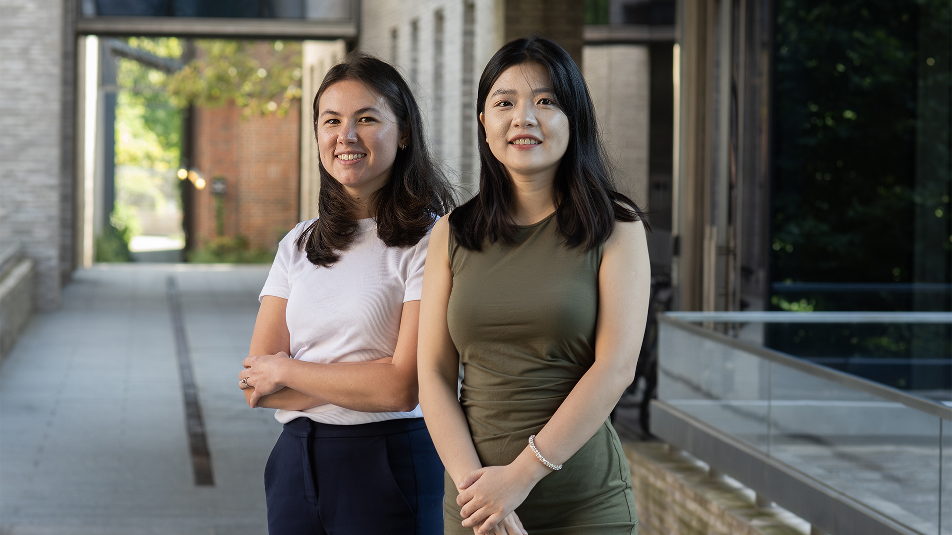 Two women stand outside of a building.