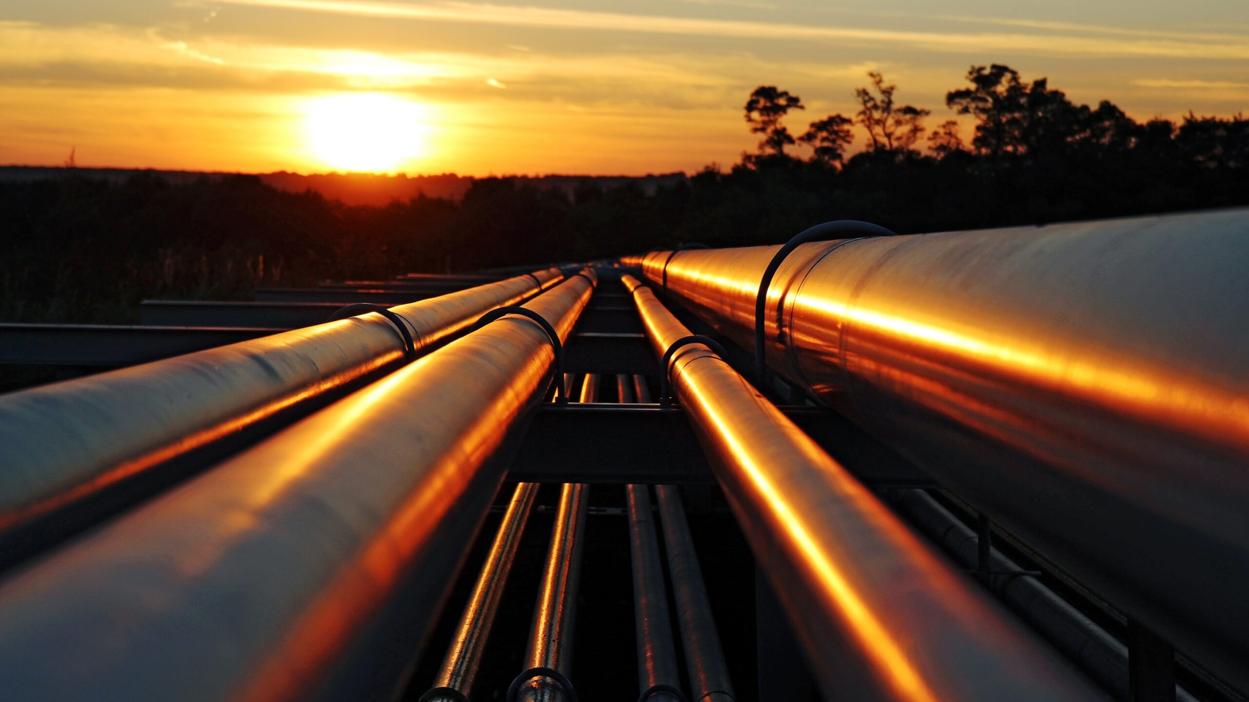 Pipelines with a sunset in the background.