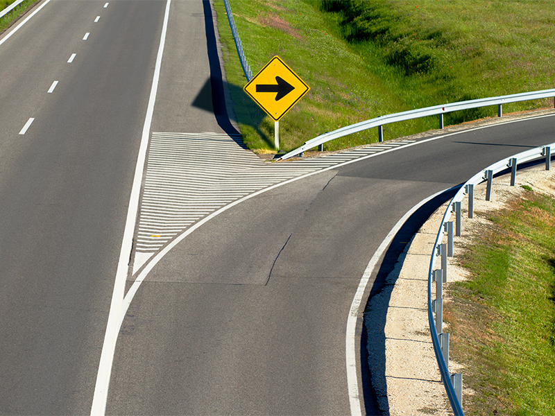 A yellow traffic sign with arrow points to an off-ramp