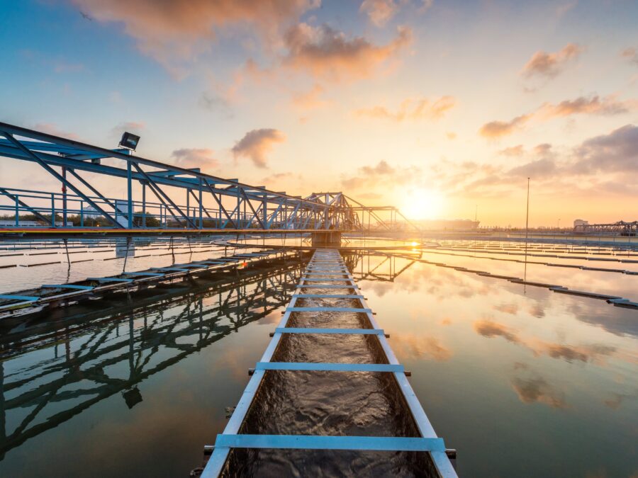 A wastewater treatment plant with a sunrise in the background.