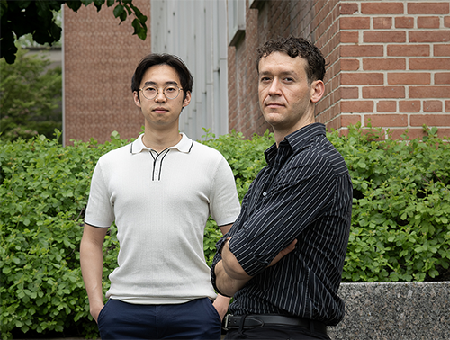 Two men pose in a garden