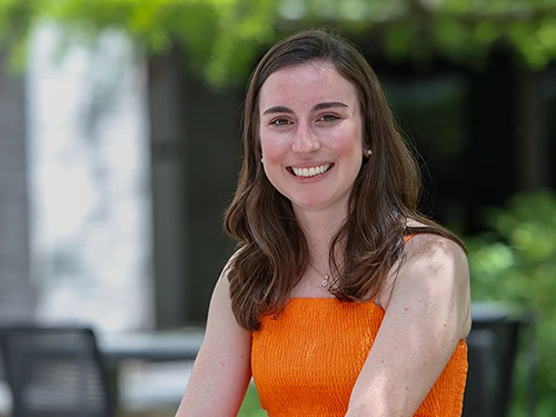Young woman in orange dress smiling