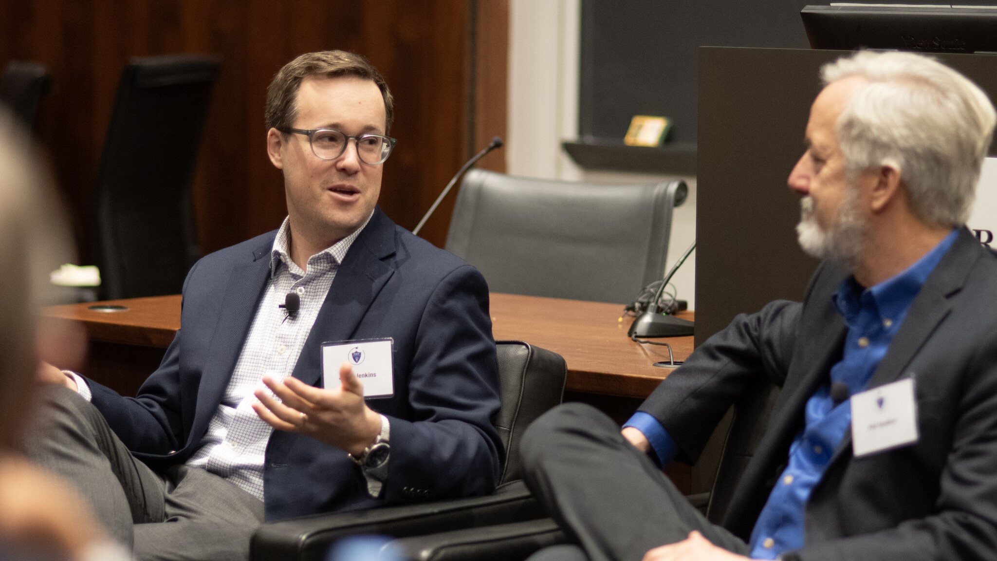 Two men converse during a panel.