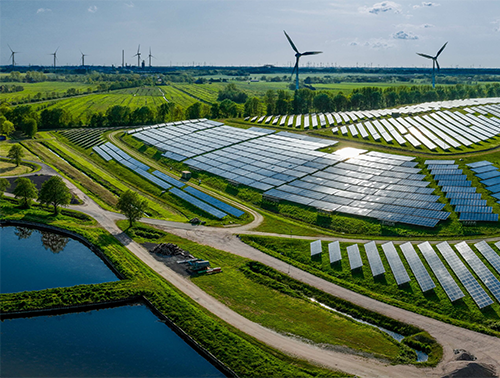 an aerial of solar panels and wind turbines