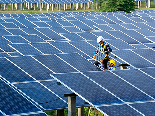two workers install solar panels