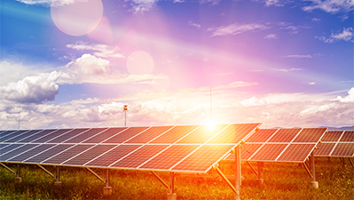 Panels of the solar energy plant under the blue sky with white clouds