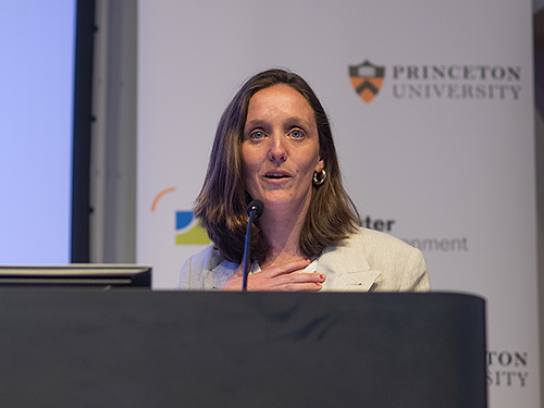 A woman stands behind a podium
