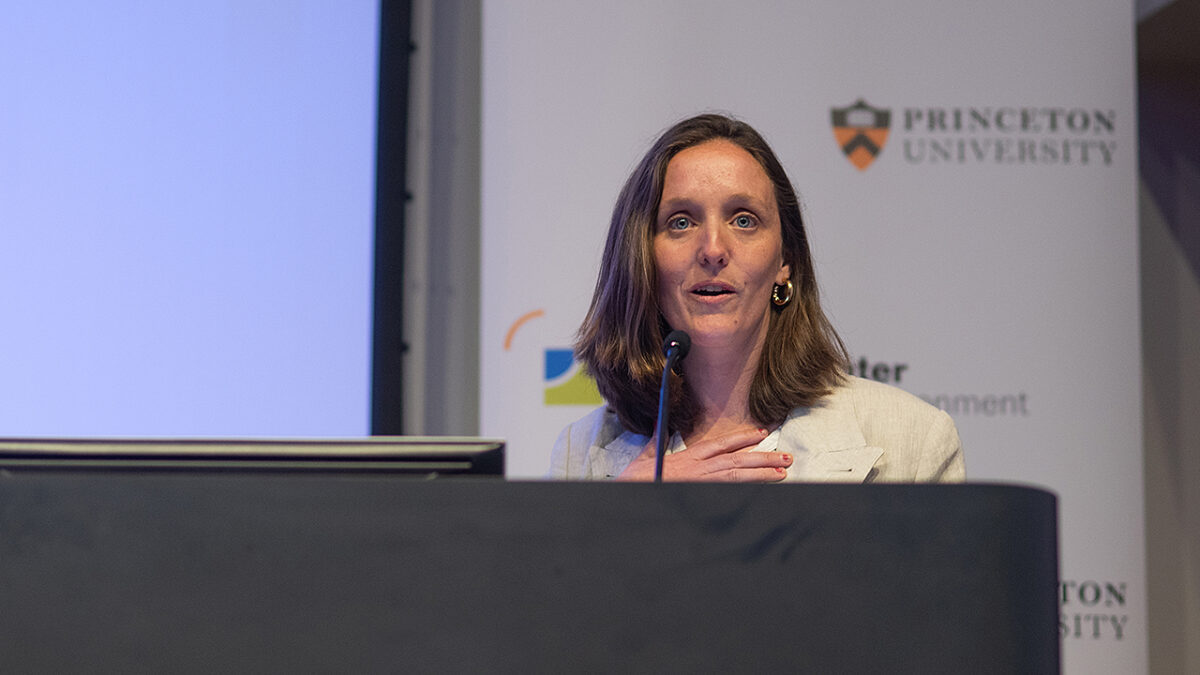 A woman stands behind a podium