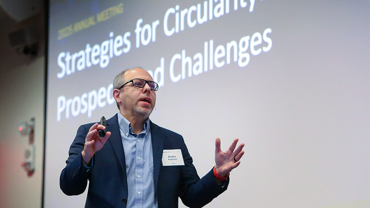 A speaker in a suit gestures passionately during a presentation on "Strategies for Circularity." The presentation is titled "Prospects and Challenges."