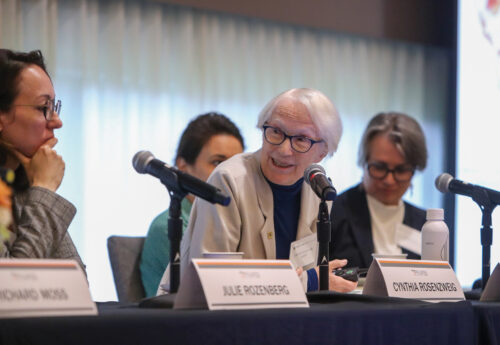 A woman during at a panel speaks into a microphone.