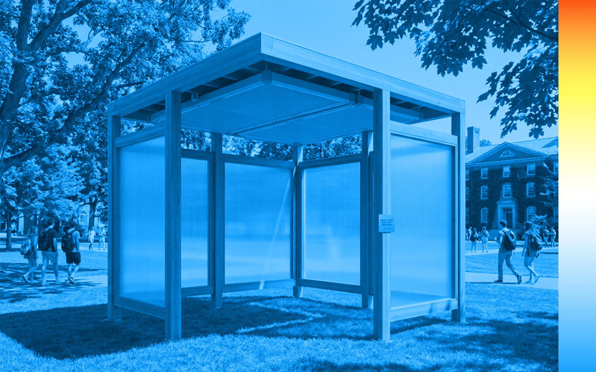 A cube-shaped outdoor structure with translucent walls and a wooden frame is set in a grassy park.