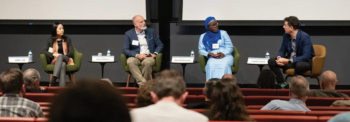 Four people in a panel discussion on-stage.