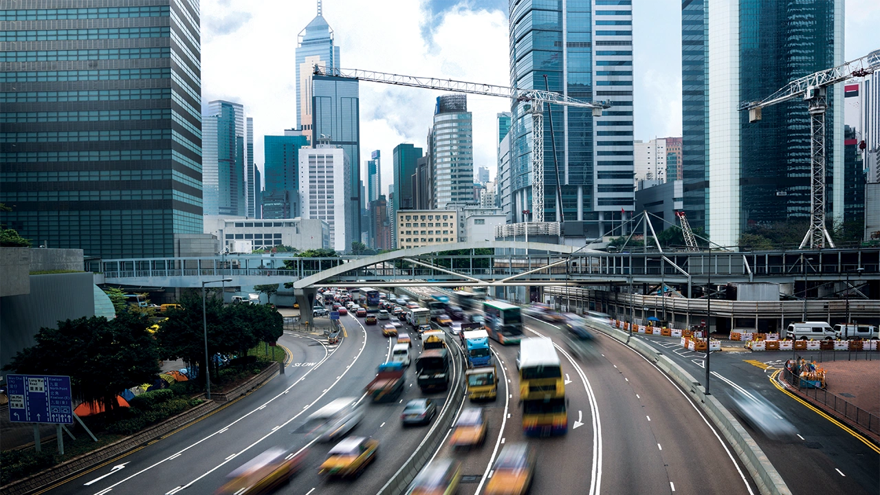 A bustling city highway with blurred motion traffic under an overcast sky.