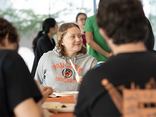 a female student smiles during an outdoor lunch