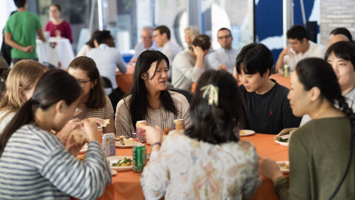 A group of students eat lunch in an outdoor setting.
