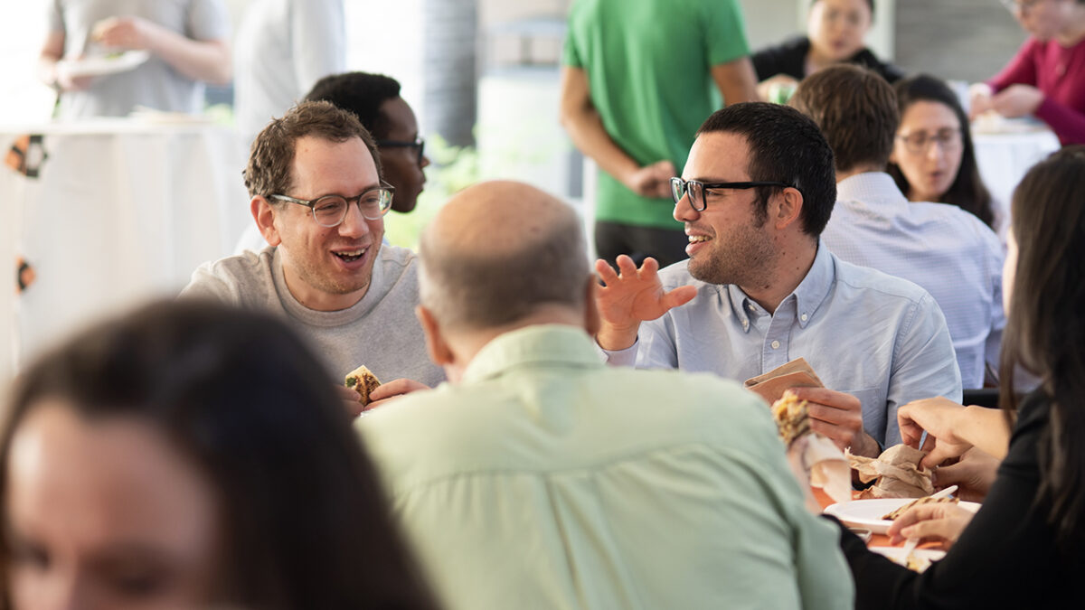 Two people share a laugh together while eating.