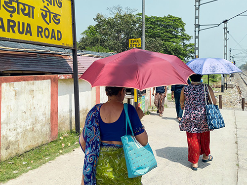 Two women in India under umbrellas